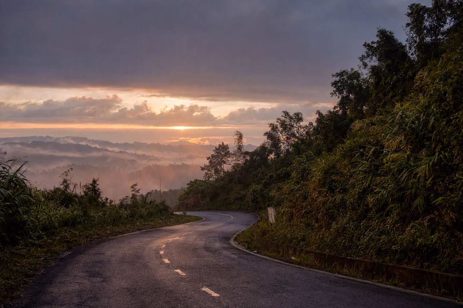 মেঘে ঢাকা সবুজ পাহাড়ের ভেতর দিয়ে আঁকাবাঁকা পথ